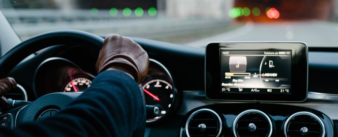 person inside vehicle holding steering wheel