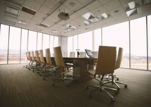 oval brown wooden conference table and chairs inside conference room